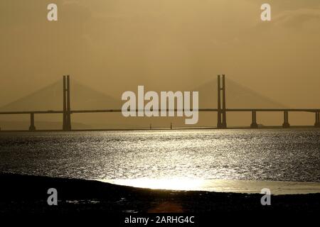 UK Weather - Beachley, Gloucestershire, UK. 28 January 2020. Setting sun over the Prince of Wales bridge carrying over the River Severn from England to Wales. Journeys over the bridge increased by 16% in the year since the tolls were removed in December 2018. Credit: Andrew Higgins/Thousand Word Media Ltd/Alamy Live News Stock Photo