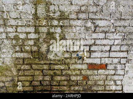 An old dirty brick wall on an abandoned industrial building Stock Photo