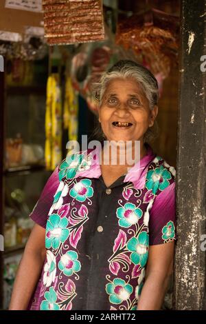 Local Woman shopkeeper, in doorway of shop, Sabaragamuwa Province, near Sinharaja Forest Reserve, Sri Lanka Stock Photo