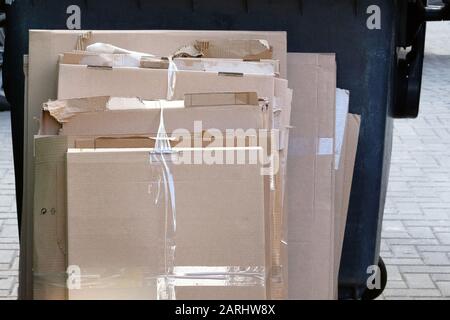 Cardboard and stacks of paper cardboard ready to be recycled. Sunny day. Urban Recycling. Stock Photo