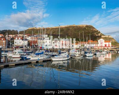 Yachts moored in the outer harbour at Scarborough Harbour below Castle Hill in Scarborough North Yorkshire England Stock Photo