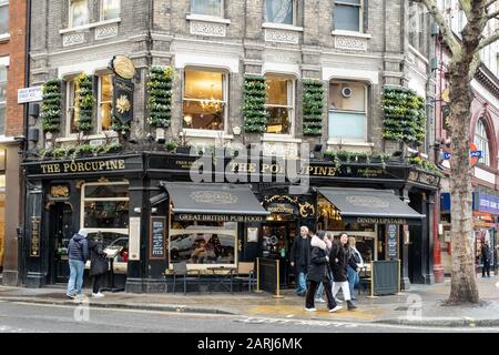 London / UK - Dec 01, 2019:  people walking past The Coach and Horses Pub on the Charing Cross Road in London, UK Stock Photo