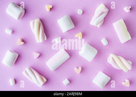 Flat lay with several types of marshmallow and soft candy on pink background Stock Photo