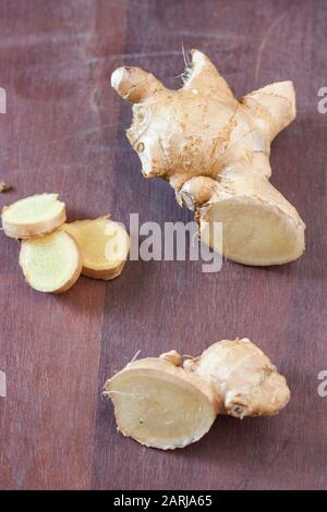 Ginger root on the wood background with leaves Stock Photo - Alamy