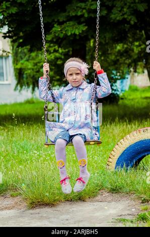 5 years old cute little girl playing in sunny summer park.Happy kid girl walking and jumping in a forest.Kids play outdoors.Kindergarten in school Stock Photo
