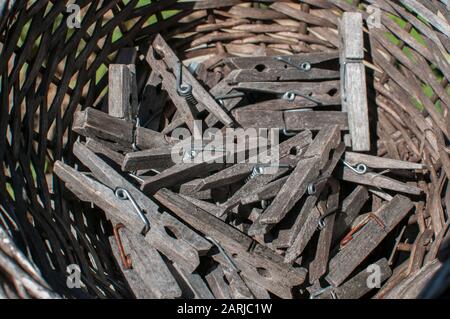Pile of weathered wooden laundry clamps closeup in reed basket Stock Photo