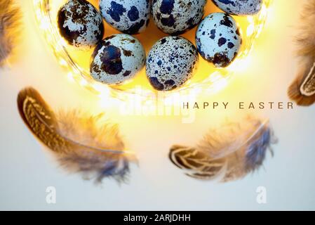 Easter card. Eggs quail and feathers in the garland Stock Photo