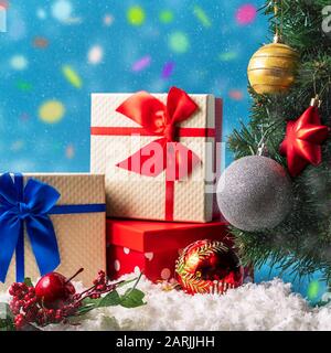 Festive Christmas and new year greeting card with gift boxes and confetti on blue background. Stock Photo