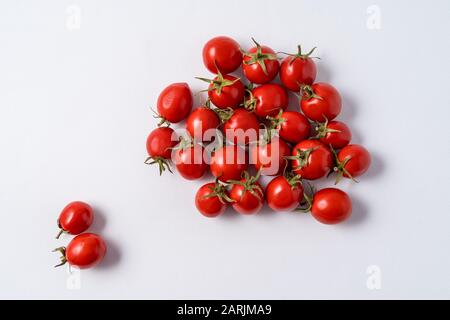 Small red ripe tomatoes pattern over white paper background. Stock Photo