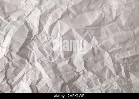 Texture of crumpled gray wrapping paper. Background of creased package paper. Empty grey crumpled paper. Copy space. Top view. Stock Photo