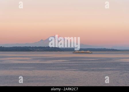 Washington State Ferry crossing Puget Sound at twilight with Mt Rainier beyond, from Seattle, Washington Stock Photo