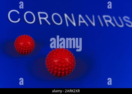 the word coronavirus laid with white letters on classic blue background. Red ball as a symbol of coronavirus. The news of the epidemic in China. Stock Photo