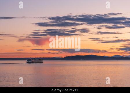 Washington State Ferry crossing Puget Sound at twilight with Olympic Mountains beyond, from Seattle, Washington Stock Photo