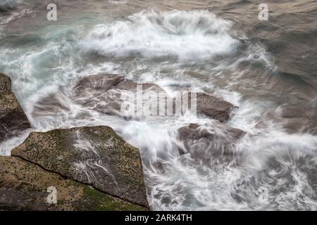 Waves breaking on to rock platrform Stock Photo
