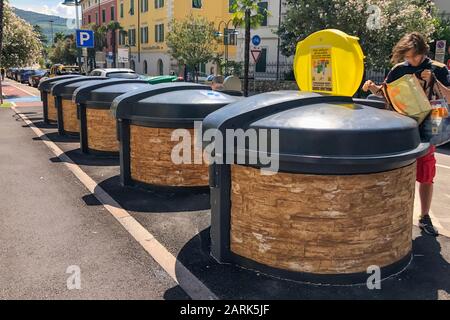 GARDA, ITALY - AUGUST 08, 2019: A man distributes garbage in different containers on the street Stock Photo