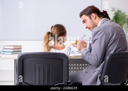 The teacher with young girl in the classroom Stock Photo