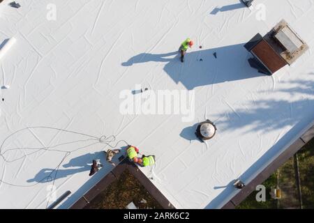 Aerial shot of construction workers on flat rooftop Stock Photo