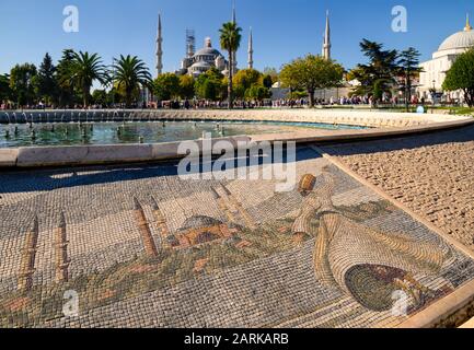 A Whirling Dervish is depicted in the mosaics on the Dancing Fountain in Sultanahmet Square in Istanbul, Turkey. The Blue Mosque is in the background. Stock Photo