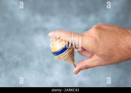 Classic wooden spinning top toy with string Stock Photo