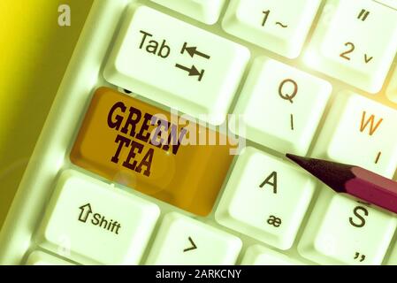 Word writing text Green Tea. Business photo showcasing type of tea that is made from Camellia sinensis leaves and buds White pc keyboard with empty no Stock Photo