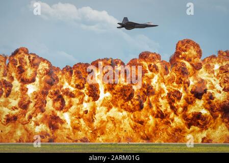 A 1,000-foot wall of fire explodes below the F-22 Raptor during a high-speed pass maneuver at the “Mission Over Malmstrom” open house event in Great Falls, Mont., July 14, 2019. The pyrotechnics are used to simulate live ordnance and the air-to-ground capabilities of the Raptor. The two-day event featured performances by aerial demonstration teams, flyovers and static displays. (U.S. Air Force photo by 2nd Lt. Samuel Eckholm) Stock Photo