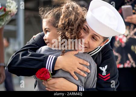 191127-N-PX867-1599 SAN DIEGO (Nov. 27, 2019) Boatswain’s Mate 2nd Class Silvia Simuel-Leon, assigned to the amphibious assault ship USS Boxer (LHD 4), holds her daughter for the first time during a homecoming gathering at Naval Base San Diego. Boxer, part of the Boxer Amphibious Ready Group (ARG), is returning to its homeport of San Diego following a 7-month deployment to the 5th and 7th fleet area of operations. (U.S. Navy photo by Mass Communication Specialist 3rd Class Justin Whitley) Stock Photo