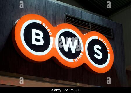 Brisbane, Queensland, Australia - 22nd January 2020 : Illuminated BWS (Beer - Wine - Spirits) sign hanging in front of a store entrance in Brisbane. B Stock Photo