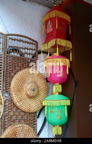 Colorful Chinese paper and Indian lanterns and straw hats  hanging outside a store in Chinatown, Vancouver, BC, Canada Stock Photo