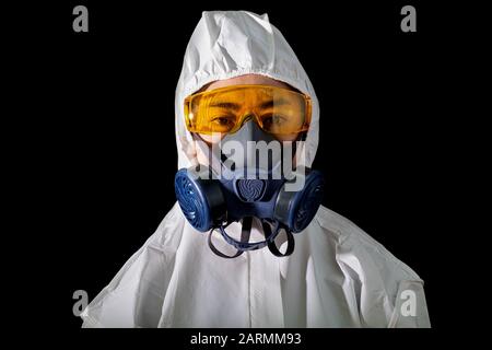 Woman in a chemical protective clothing and antigas mask with glasses at white background, Women scientist in safety suit, Safety virus infection conc Stock Photo