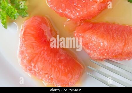 Grapefruit and honey salad - top view photo of grapefruit segments close up with parsley and honey Stock Photo
