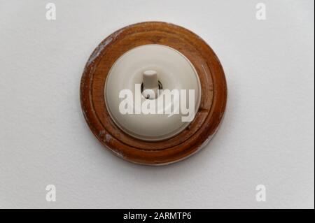 A light switch is in the off position on a wall Stock Photo