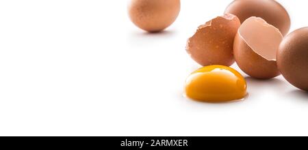 Chicken eggs and broken egg with yolk isolated on white background. Stock Photo