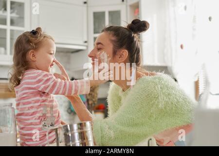 Mother and daughter having fun with flour in the kitchen Stock Photo