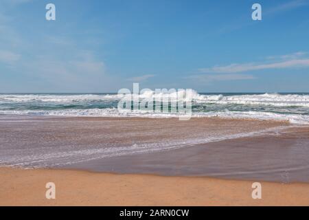 Beautiful seascape. Stormy ocean, sand beach, and cloudy sky Stock Photo