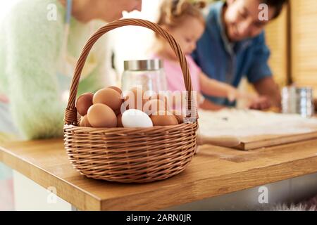 A full basket of eggs and family in the background Stock Photo