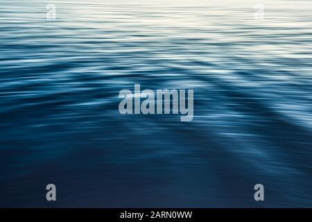 Calm water abstract background, water surface, soft blue color, play of ripples Stock Photo