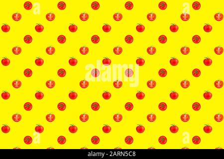 Pattern of red tomatoes on bright yellow background top view, colorful cut and whole tomato wallpaper, fresh vegetables design flat lay Stock Photo