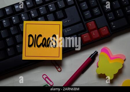 DICaaS - Data Intensive Computing as a Service write on a sticky note isolated on office desk. Stock Photo