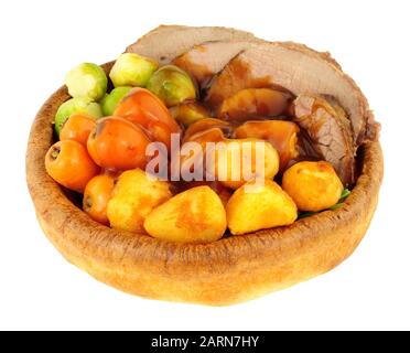 Roast beef meal in a Yorkshire pudding with roasted potatoes and vegetables isolated on a white background Stock Photo