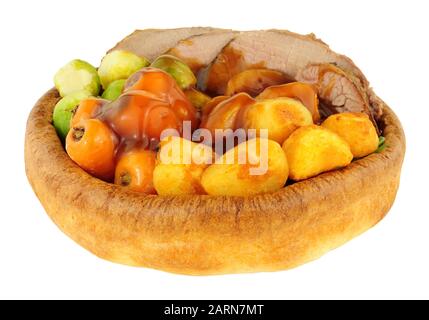 Roast beef meal in a Yorkshire pudding with roasted potatoes and vegetables isolated on a white background Stock Photo