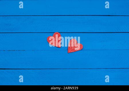 Two red hearts on blue wooden background, close-up, Stock Photo