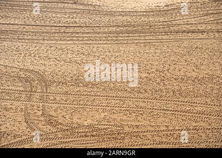 Tire tracks and footprints all over the sandy beach. Taken in Albuferia, Portugal Stock Photo