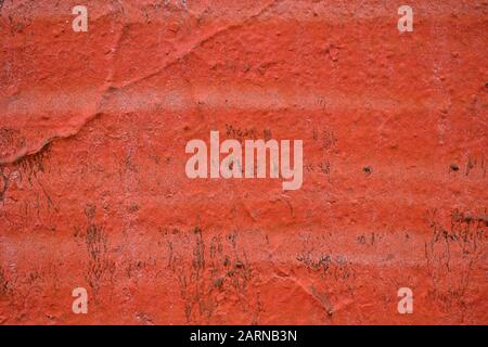 The painted wall of the facade is in bright red. Texture, background. Stock Photo