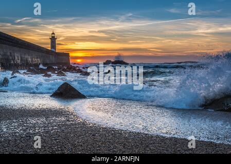 View from Carneiro beach on a Felgueiras Lighthouse during sunset over Atlantic Ocean in Foz do Douro district of Porto city, Portugal Stock Photo