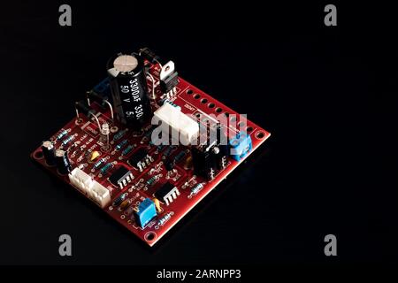 Red PCB with resistors on black background Stock Photo