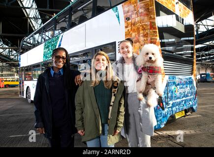 EMBARGOED TO 0001 THURSDAY JANUARY 30EDITORIAL USE ONLY (Left to right) Jackie Poyer-James, Bea Graham, Aislin Smith and dog Faith attend the unveiling of a one-of-a-kind mosaic bus livery, which features the faces of Stagecoach customers and drivers from across the UK, is unveiled to celebrate the launch of its new look bus design in its 40th year of service, at the Chesterfield depot in Derbyshire. PA Photo. Issue date: Thursday January 30, 2020. The one-off design created using photos from a year-long project with photographer Stuart Roy Clarke launches Stagecoach's new look colour coded bu Stock Photo
