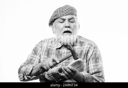 mature shoemaker in workshop make shoes. Cobbler workmanship. shoemaker working with leather textile and hammer at workshop. retro man repair shoes with hammer. shoemaker at work. at shoe store. Stock Photo