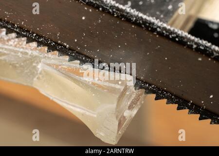 Sawing glass with a saw lose up Stock Photo