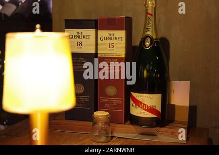 G. H. Mumm champagne and The Glenlivet single-malt scotch whisky packages displayed on wooden table