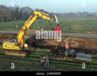 Wriezen, Germany. 27th Jan, 2020. Employees of Ingenieur Wasser und Tiefbau GmbH (IWT) Frankfurt (Oder) are inserting special grids into the soil on one side of a trench (recorded with a drone). The patent of the Frankfurt company slows down the beavers in the Oderbruch. At moats and dikes, vertically buried protective mats prevent nocturnal animals from digging into the ground. Nevertheless, the beaver feels right at home in the cultural landscape. Credit: Patrick Pleul/dpa-Zentralbild/ZB/dpa/Alamy Live News Stock Photo